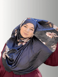 A handmade hijab featuring a dark gray base with intricate floral patterns in soft pink, cream, and burgundy tones, elegantly draped to showcase its lightweight, non-slip fabric and refined design.
