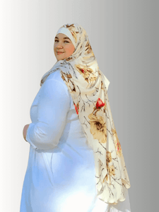 Woman wearing golden Blossom Veil hijab in a floral pattern complimented by a solid white dress 