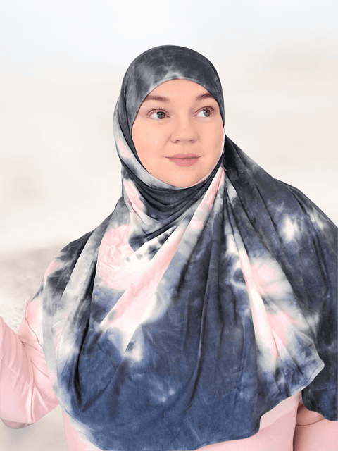 Marble hijab shawl in light pink shades mixed with dark gray colors woman gazing in the distance with a modest smile 